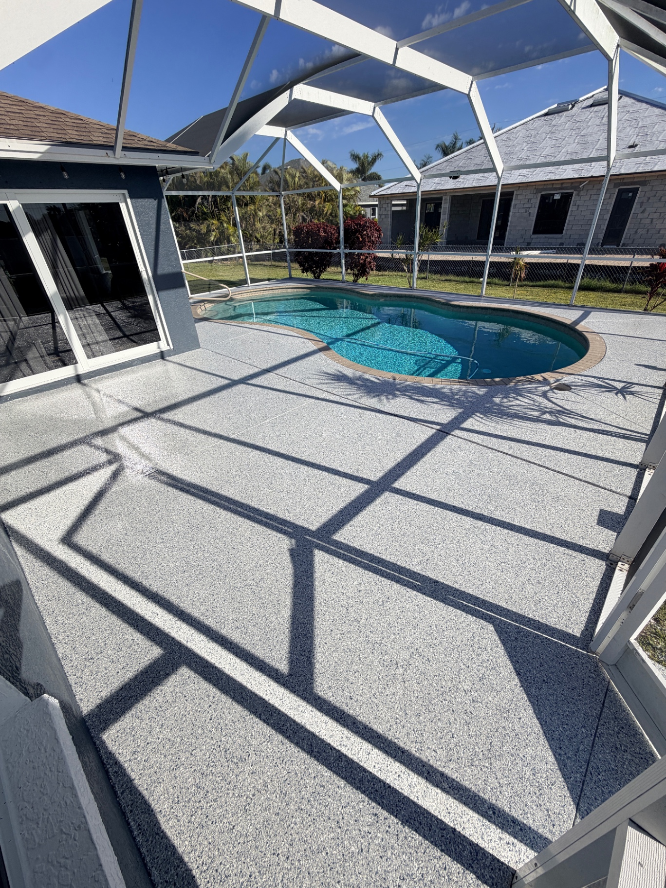 Epoxy pool deck wide view with screen enclosure